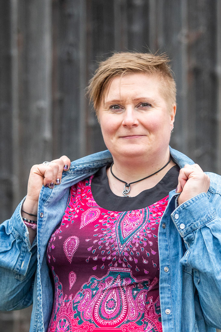 Nainen luonnossa kahvikuppi kädessään.